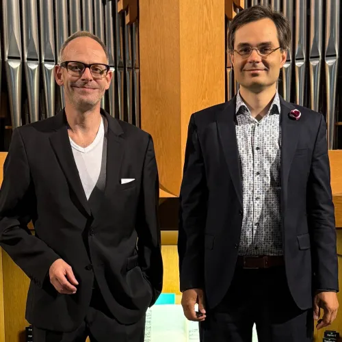 Die beiden Organisten stehen vor einer Orgel